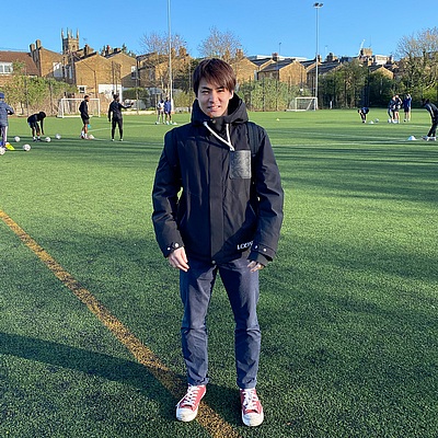 サッカーグラウンドに立つコーチング留学生