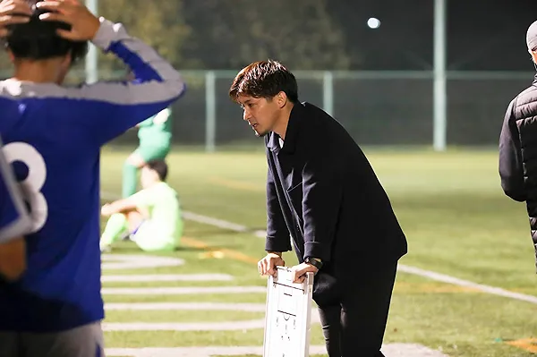 サッカーの試合中に選手へ指示を送るKens SE選抜チーム監督の大塚翔氏